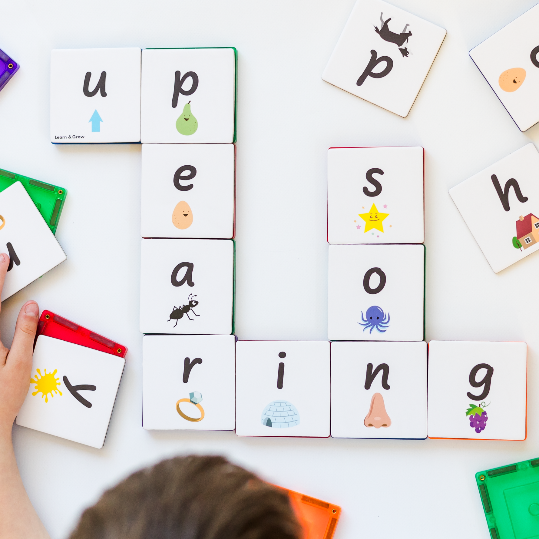 Lowercase tile toppers stuck to magnetic tiles used as a crossword