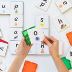 Hands showing putting an lowercase o tile topper onto a green magnetic tile