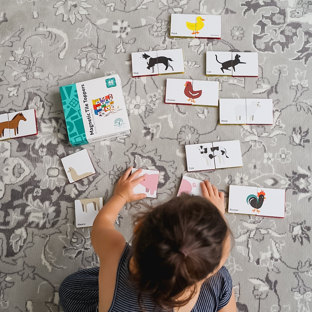 Child playing on the floor with Learn & Grow Toys Animal Duo Puzzle pack 