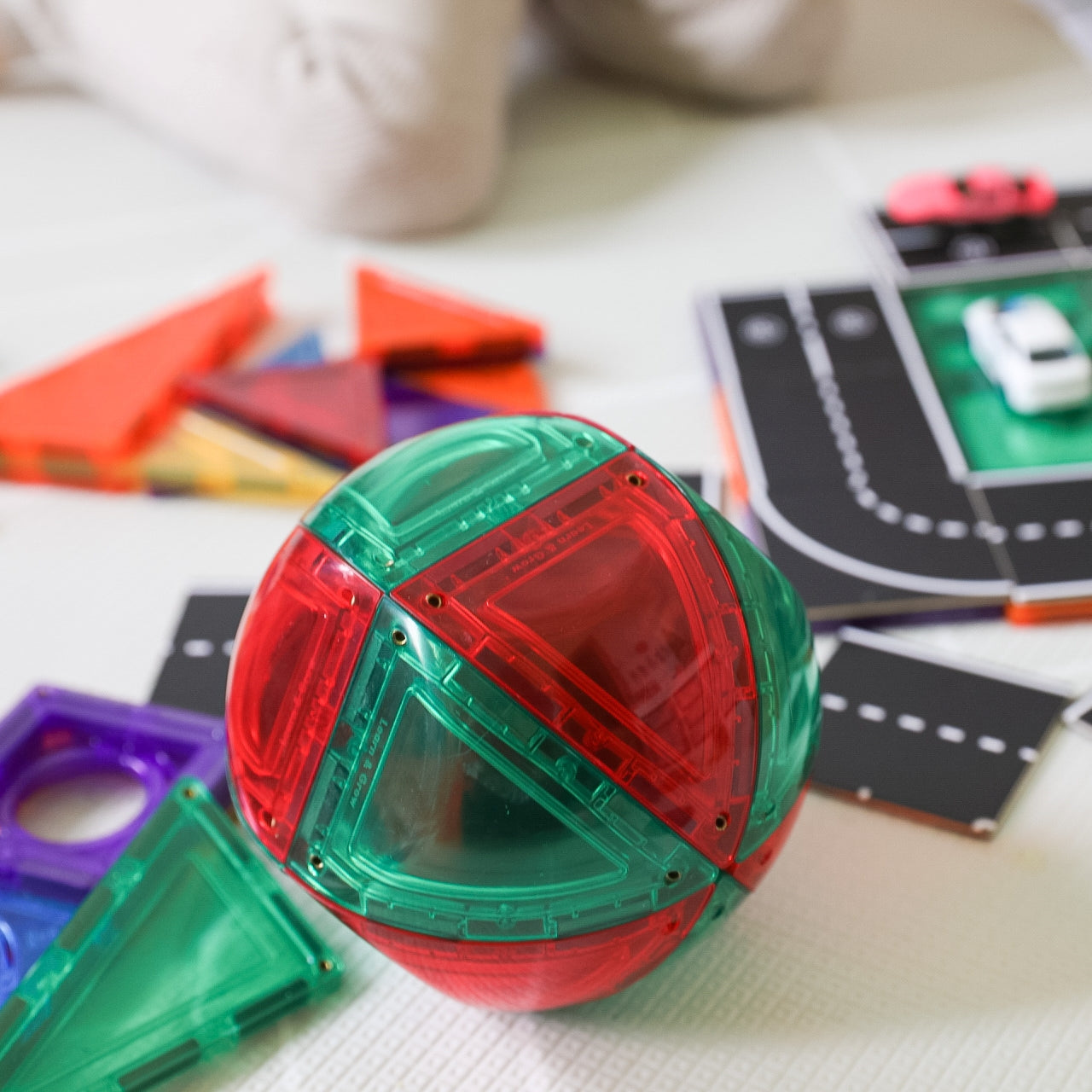 Red and green dome sitting with road toppers on floor