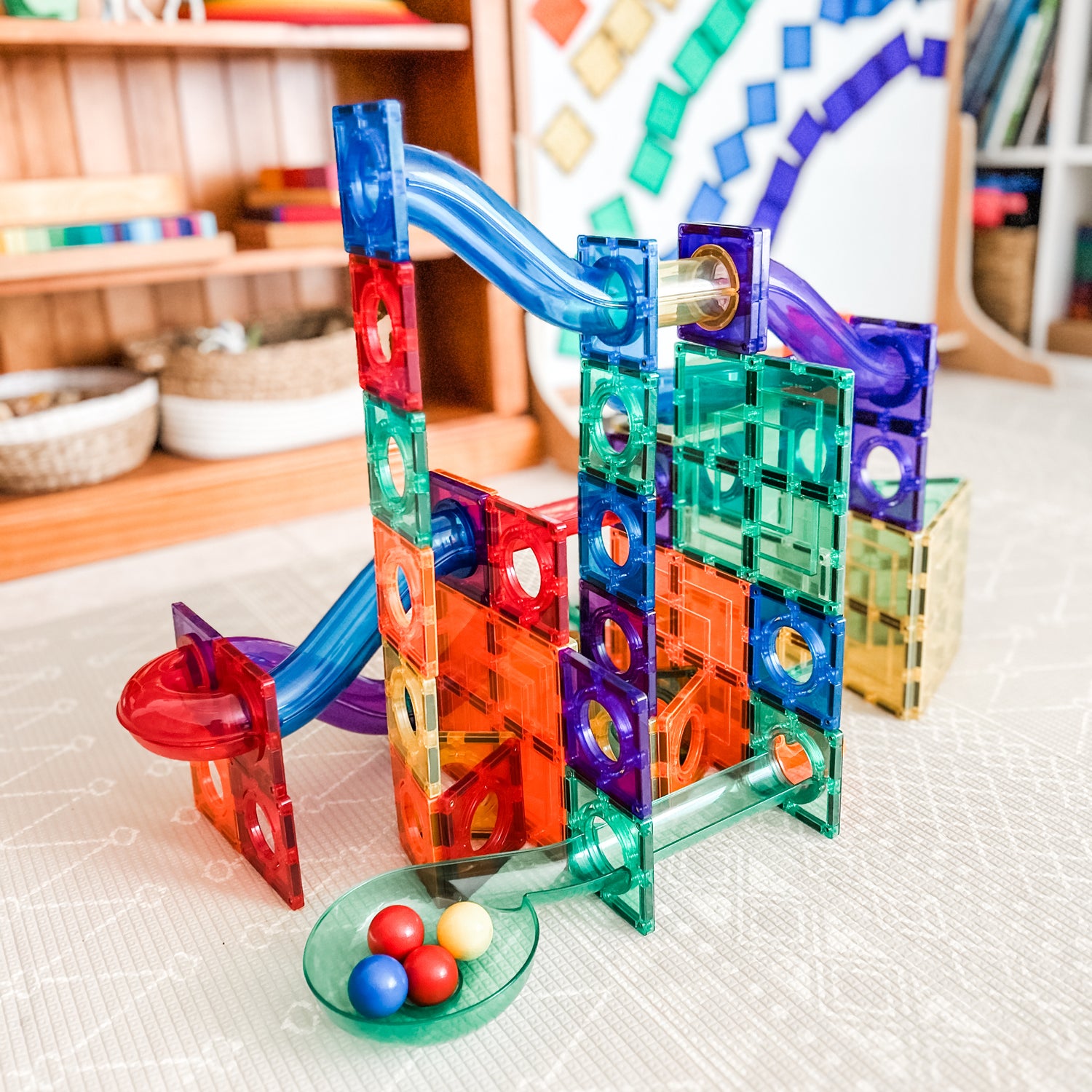 Magnetic marble ball run set up in playroom with multi board in background