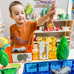 Child playing with a giraffe and magnetic tile houses set up with duo animal puzzle on the front 