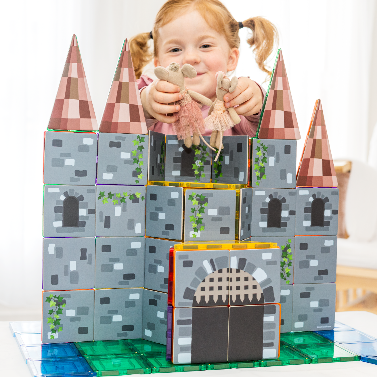 Girl playing with a castle made from magnetic tile toppers