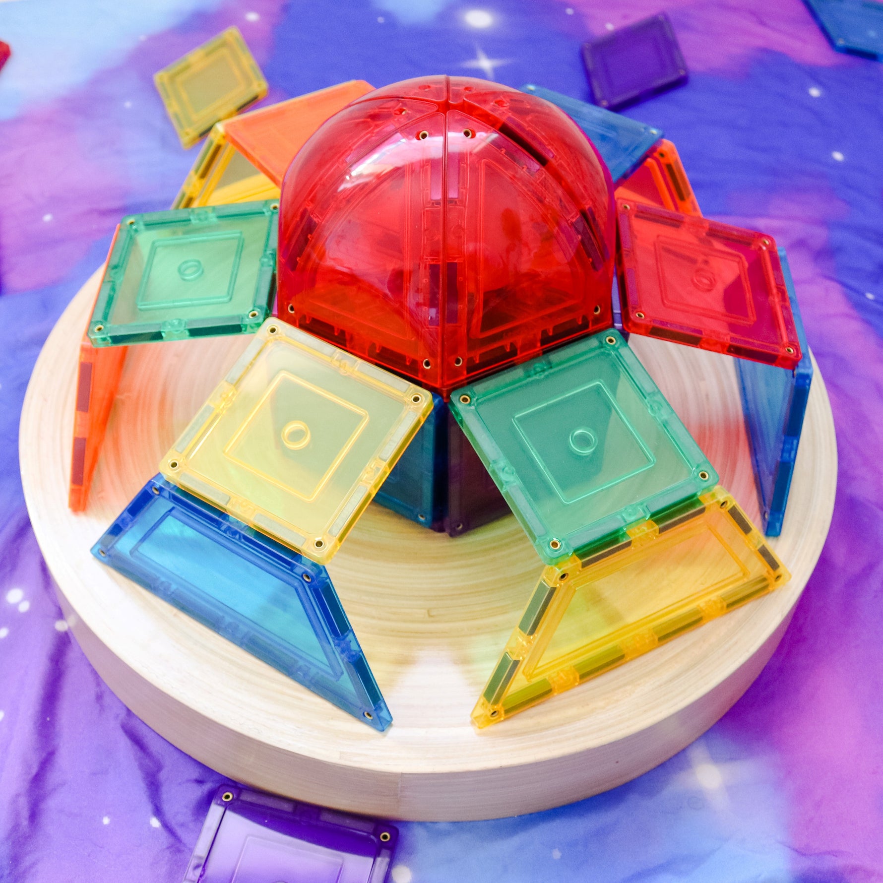 Magnetic dome set by Learn & Grow Toys turned into a spaceship with purple starry silk underneath