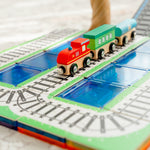 Close up of wooden trains sitting on magnetic tile train toppers with magnetic tiles